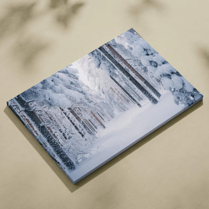 Canvas wall art featuring a serene snowy forest landscape with tall snow-covered trees and soft blue-gray tones.