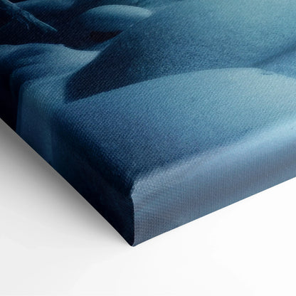 Canvas wall art corner showing textured fabric with deep blue and black hues of a snowy forest scene.