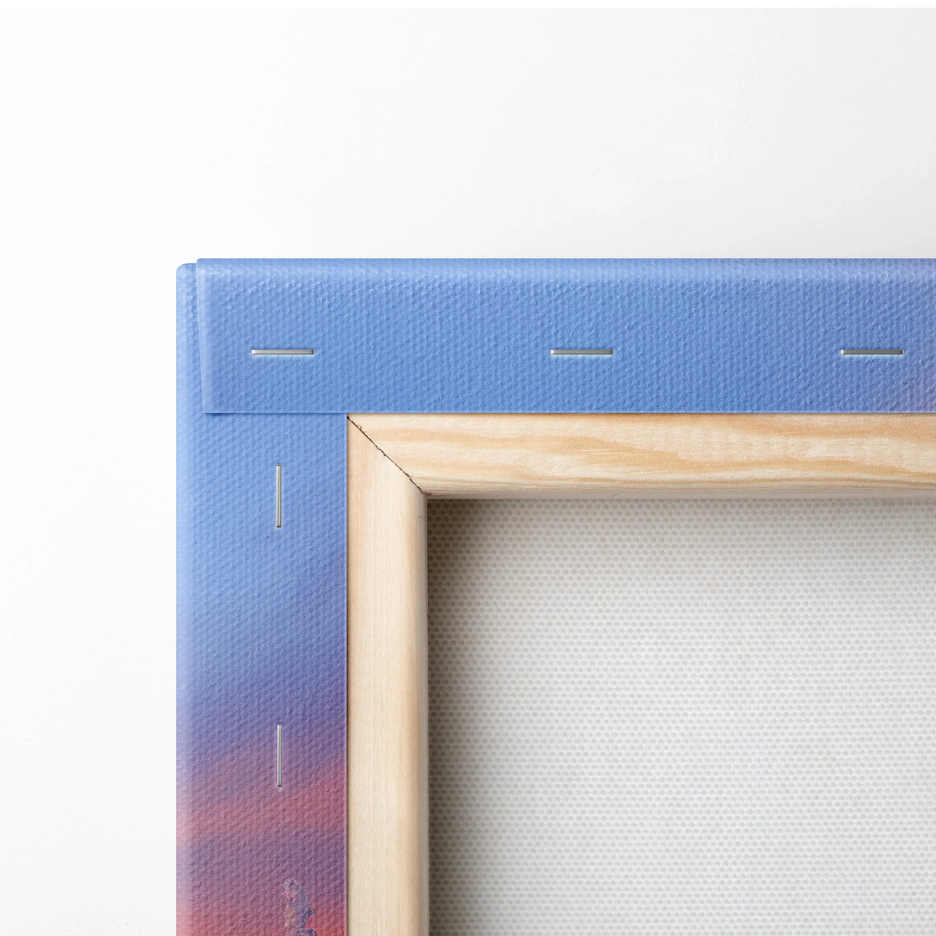 Close-up of canvas wall art corner showing purple and orange printed fabric wrapped around wooden stretcher bars.