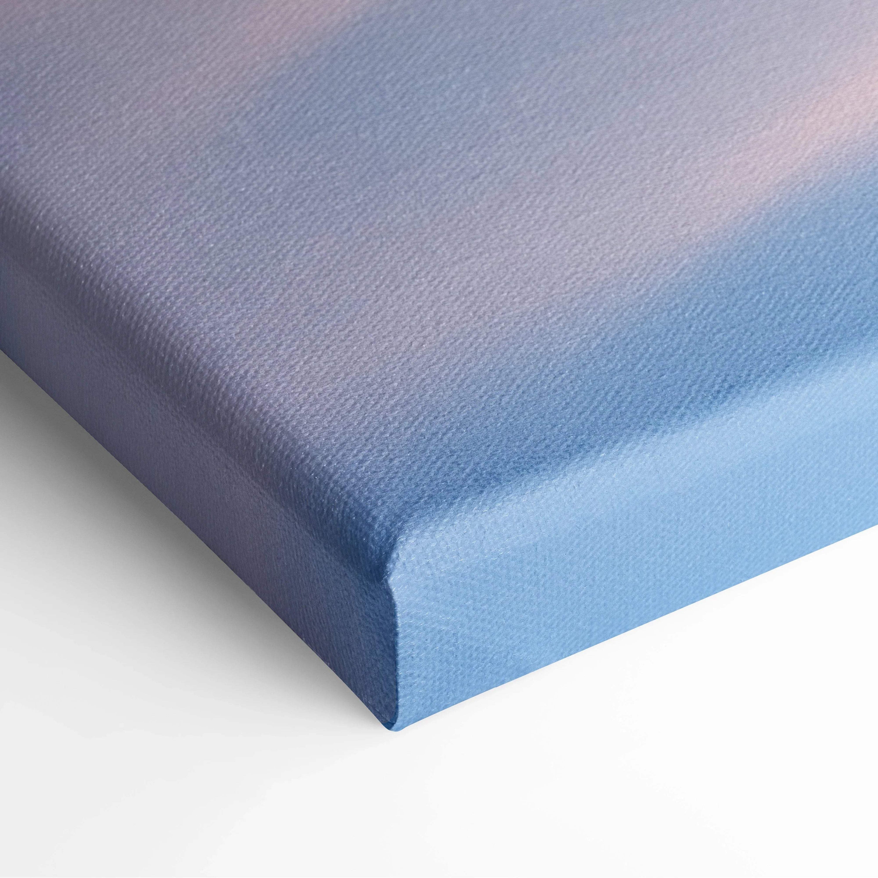 Close-up of canvas wall art corner with soft gradient sky in pastel blue and pink hues on textured fabric surface.