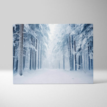 Canvas wall art featuring a snowy winter forest landscape with tall, snow-covered pine trees and a misty, serene atmosphere.