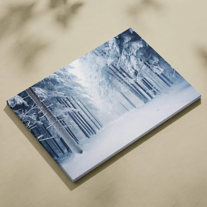 Canvas wall art featuring a snowy forest landscape with tall trees and soft blue tones.
