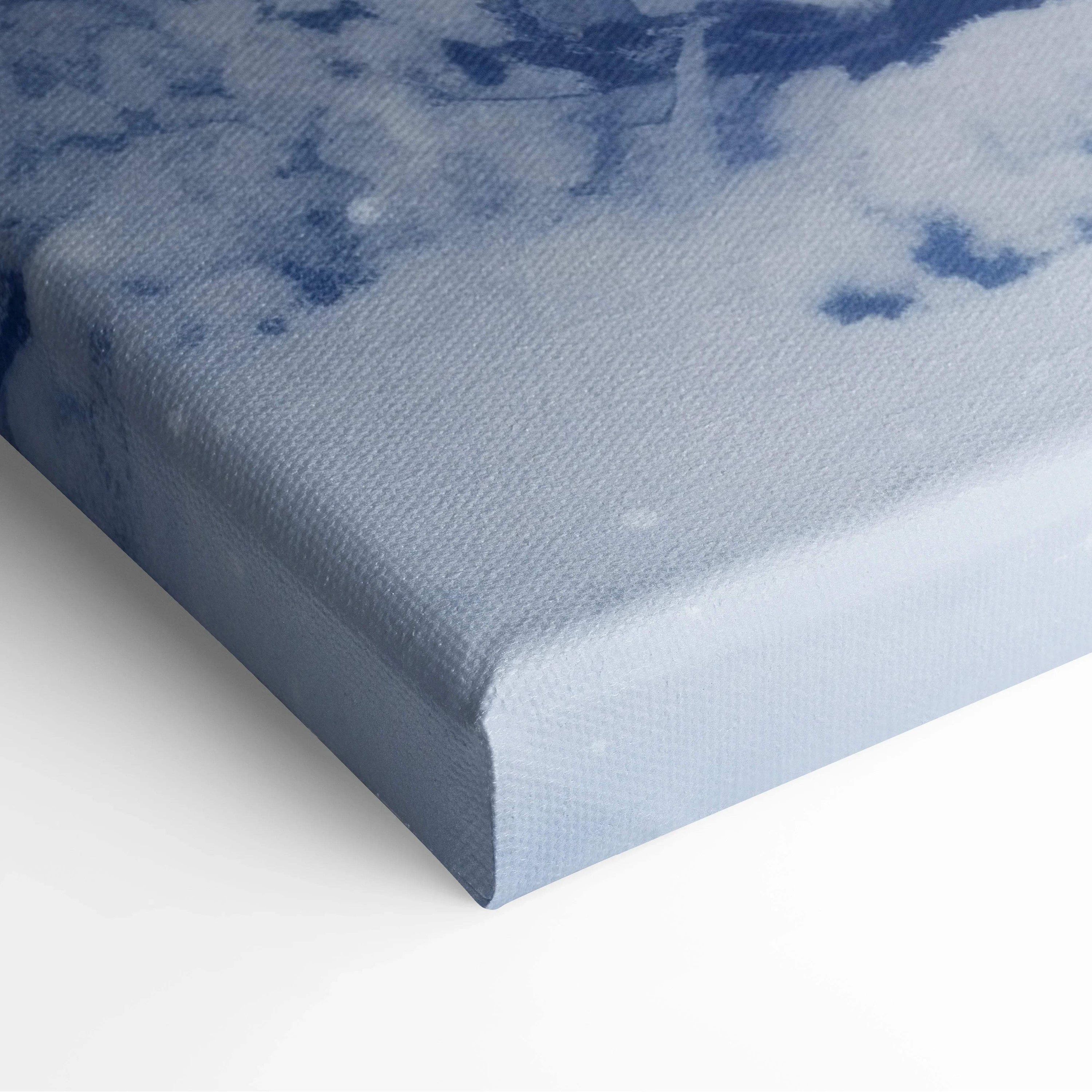 Close-up of thick canvas wall art corner with soft blue and white snowy winter digital print texture.