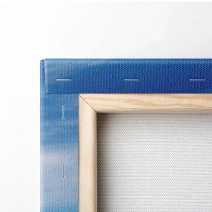 Corner close-up of blue stretched canvas art with natural wood frame and visible staples on the back.