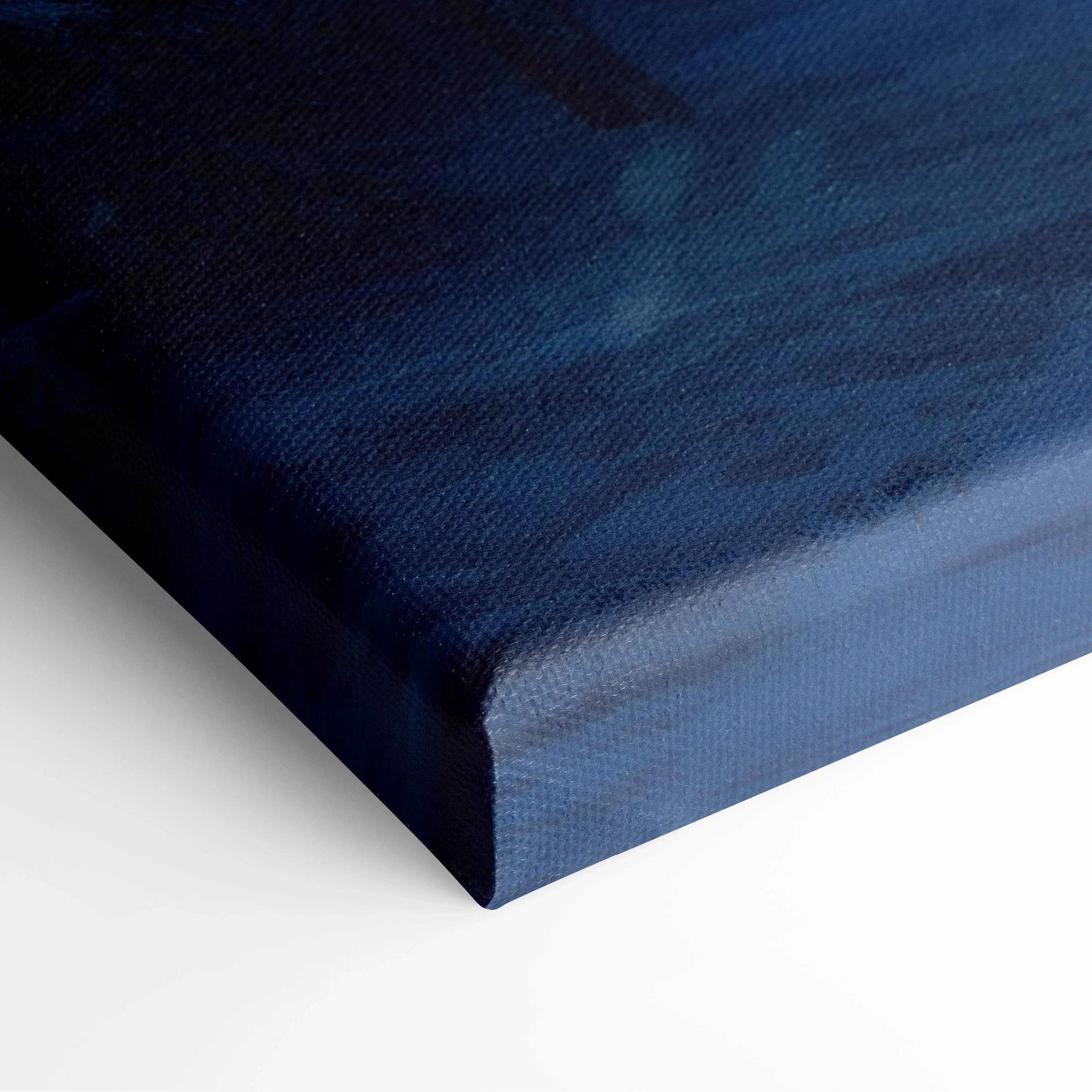 Close-up of canvas wall art depicting a dark blue winter night with swirling snow, textured surface visible.