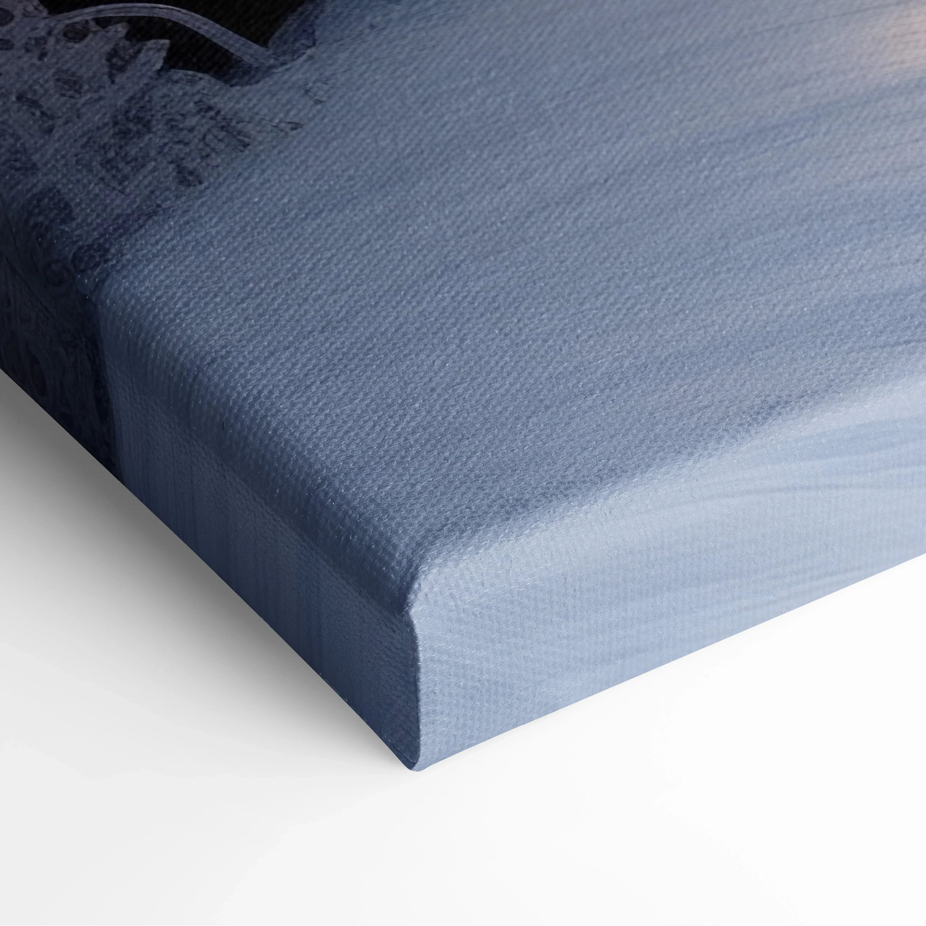 Corner close-up of wrapped canvas with textured fabric and soft blue-gray tones in winter landscape print.
