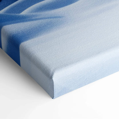 Close-up of blue and white snowy scenery printed on textured canvas wall art with sharp edges for home decor.