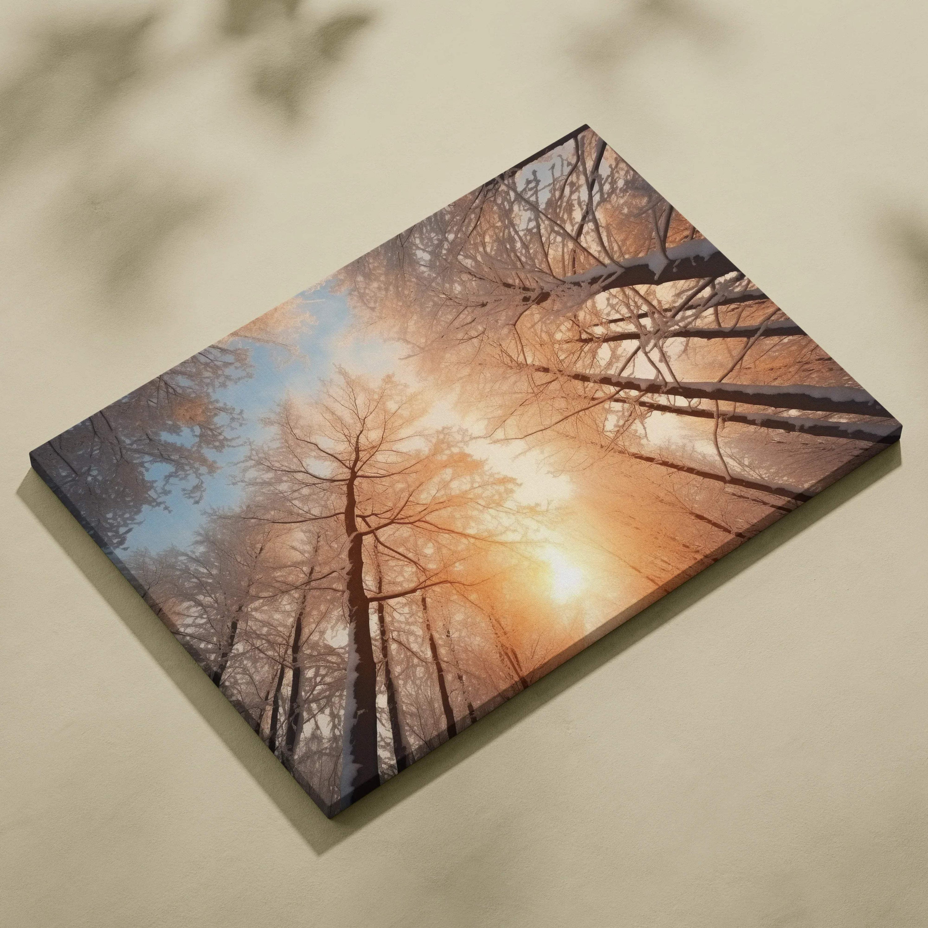 Canvas wall art featuring a snowy forest with tall trees and a warm sunset glow in soft orange and blue tones.
