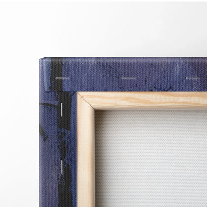 Close-up of wooden frame corner with stretched white canvas and part of dark blue printed canvas wrap edges for wall art.