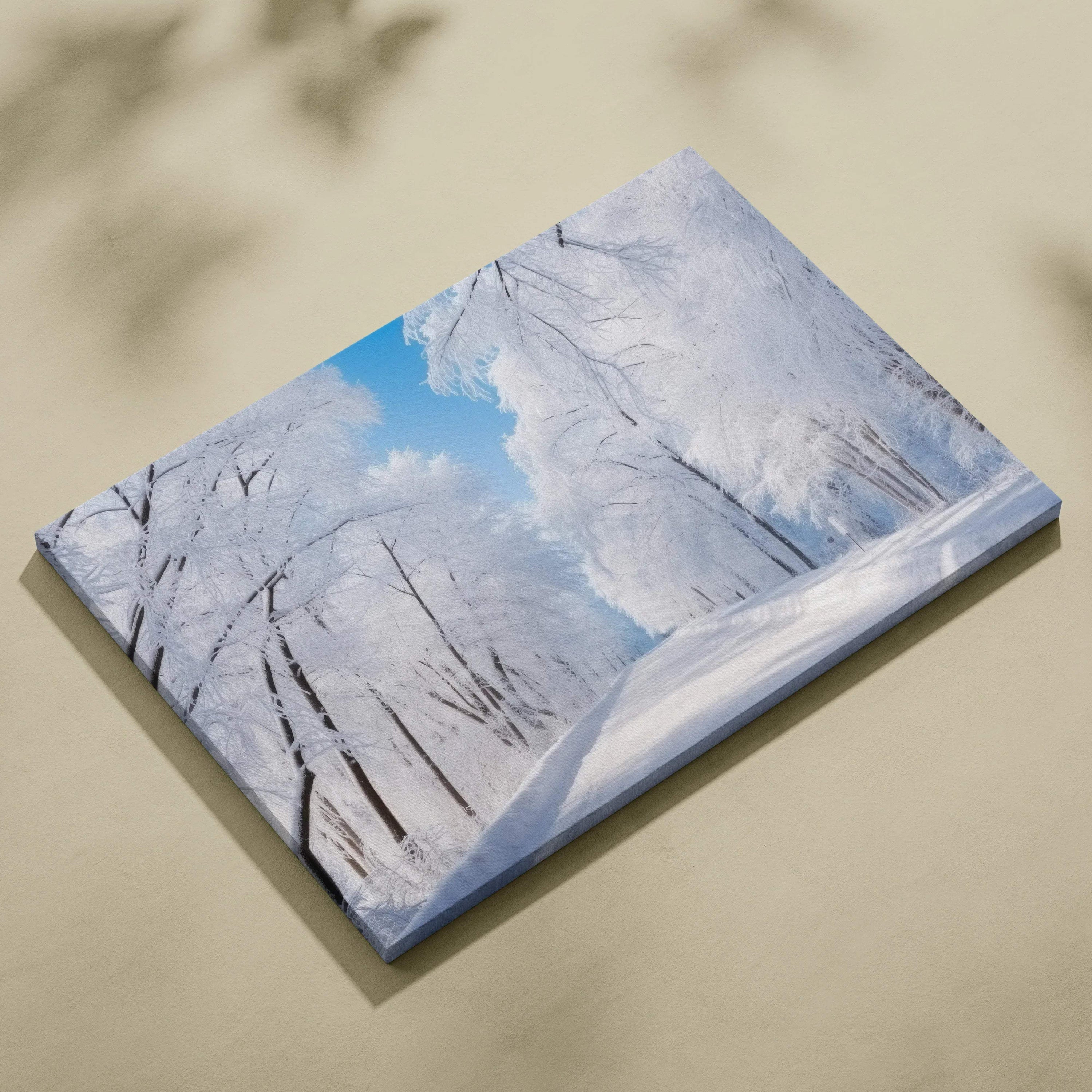 Canvas wall art featuring a snowy winter landscape with bare trees under a bright blue sky.
