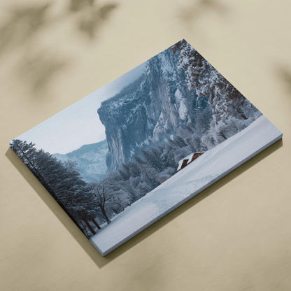 Snowy mountain landscape canvas print with rustic alpine cabin and cliffs