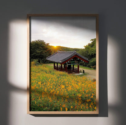 Serene sunset over traditional building with vibrant orange flowers poster wall art.