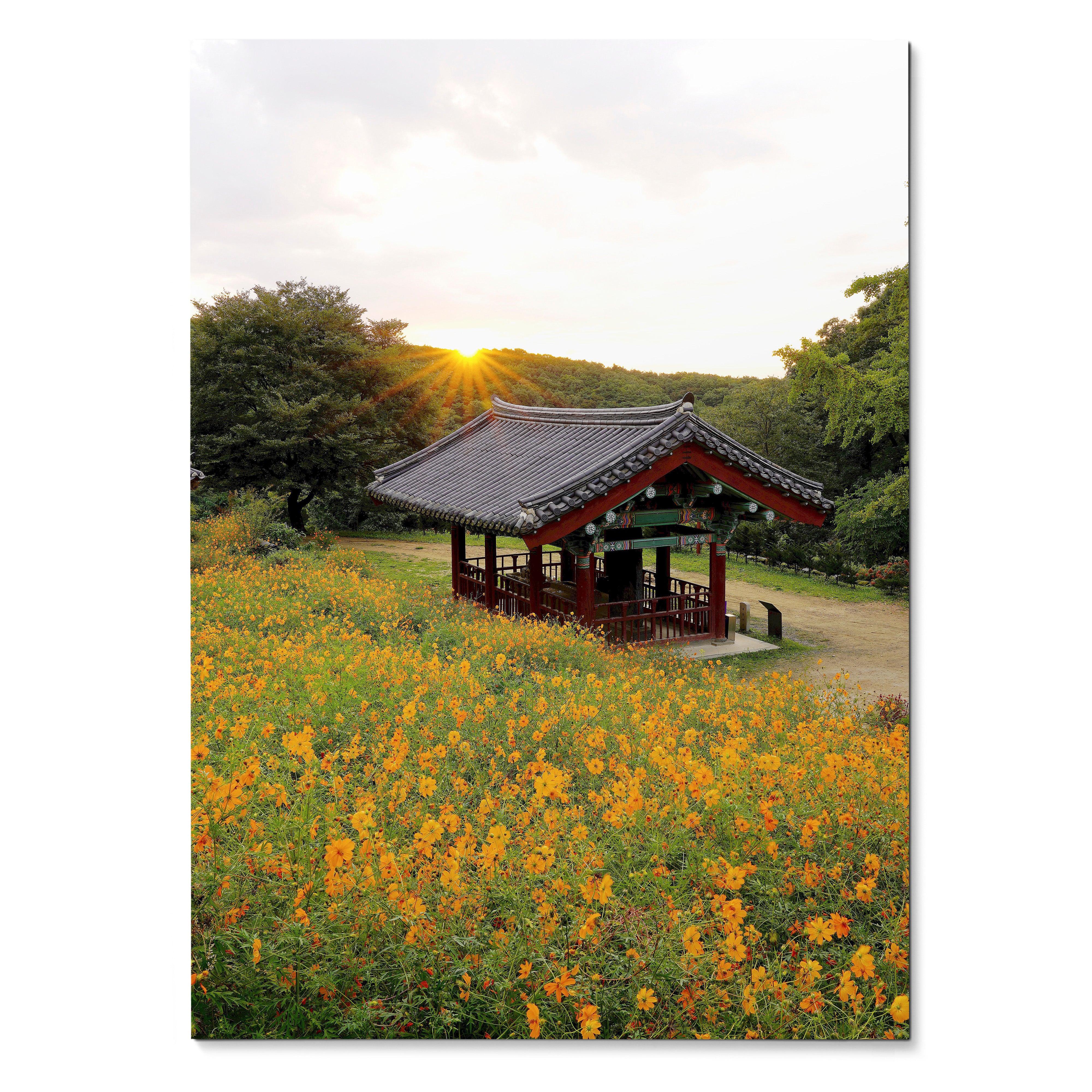 Vertical wall art poster featuring a rustic pavilion amid orange floral field at sunset.